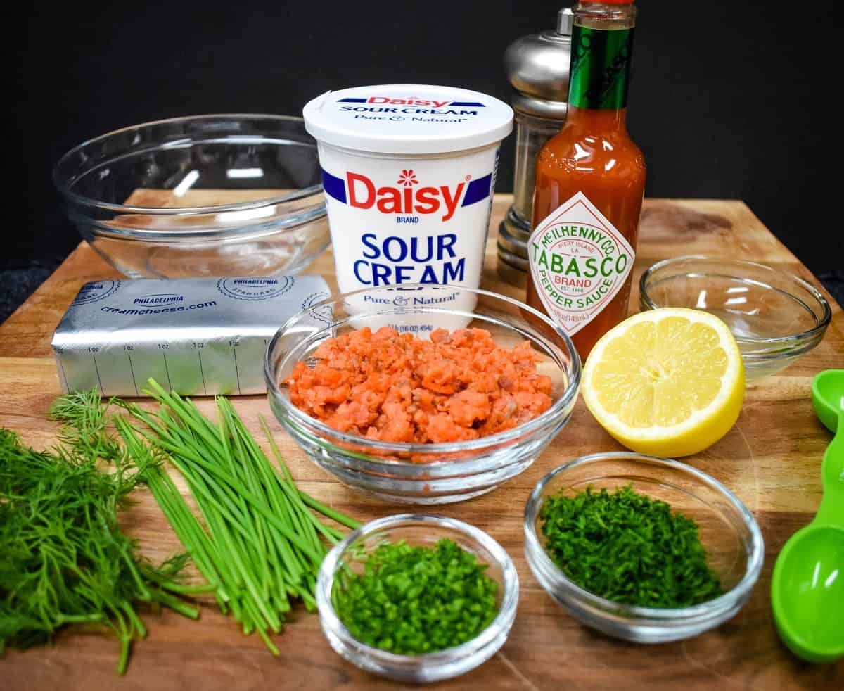 The ingredients for the salmon dip displayed on a wood cutting board.