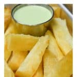 Yuca frita served with a light green cilantro sauce.