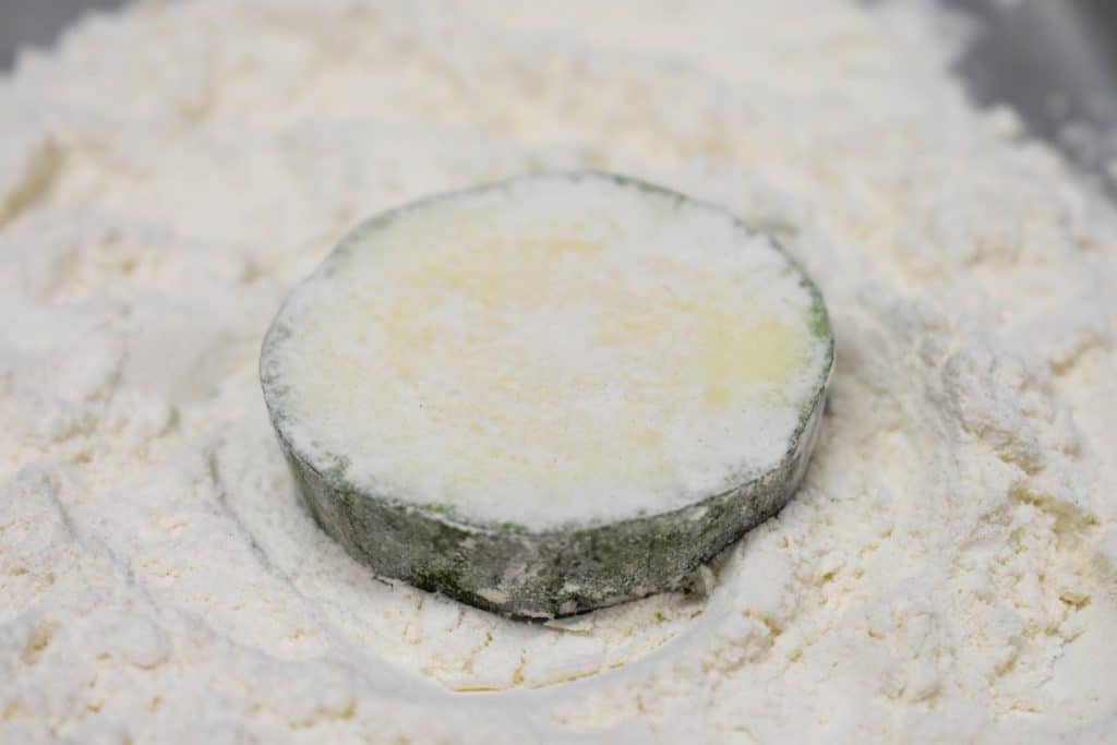 A zucchini round lightly coated in flour.