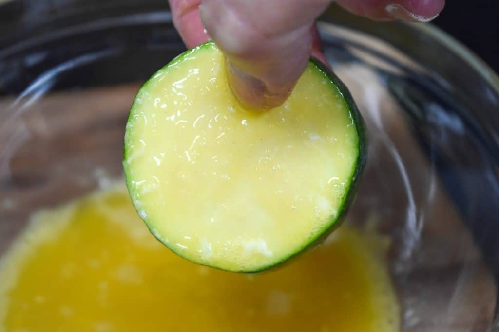 A zucchini round after being dipped in egg.