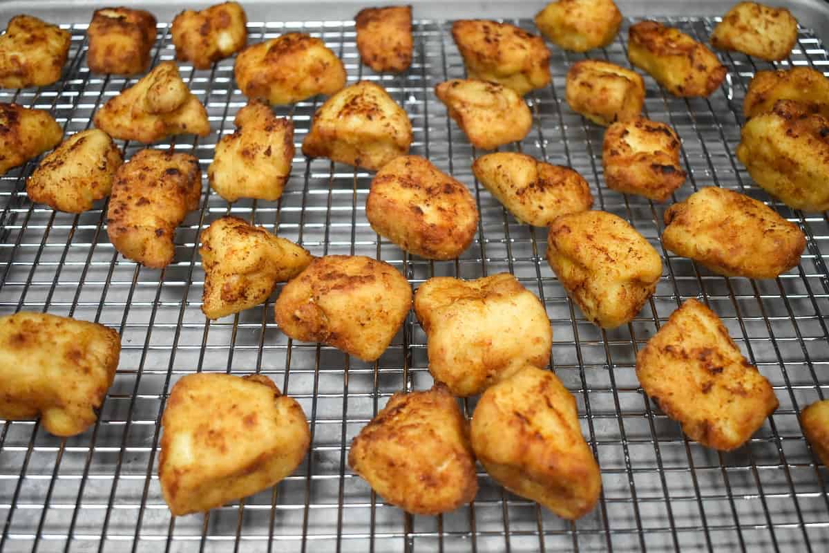 Fried chicken bites on a large cooling rack.