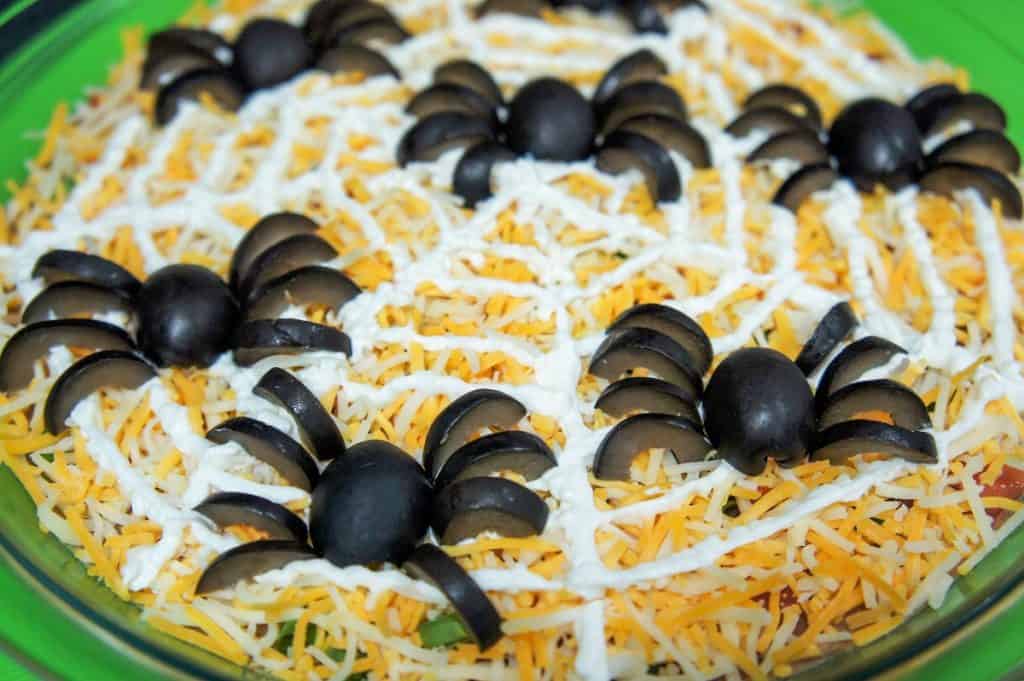 A bean dip with spiders made from black olive pieces.