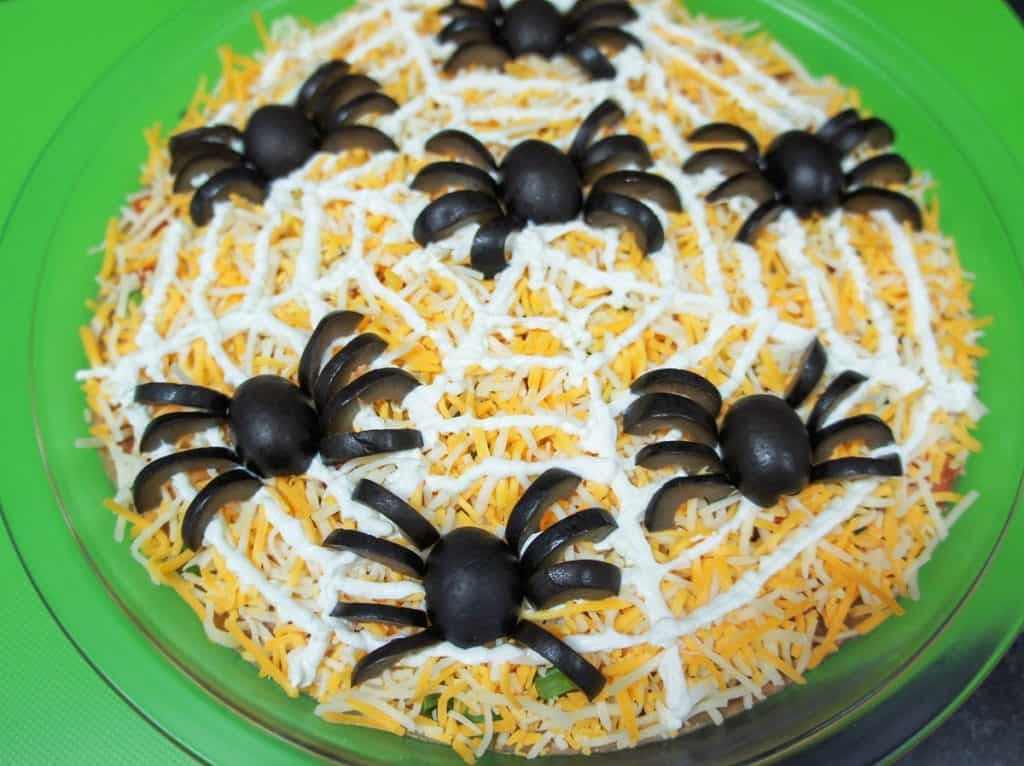 A bean dip with spiders made from black olive pieces.