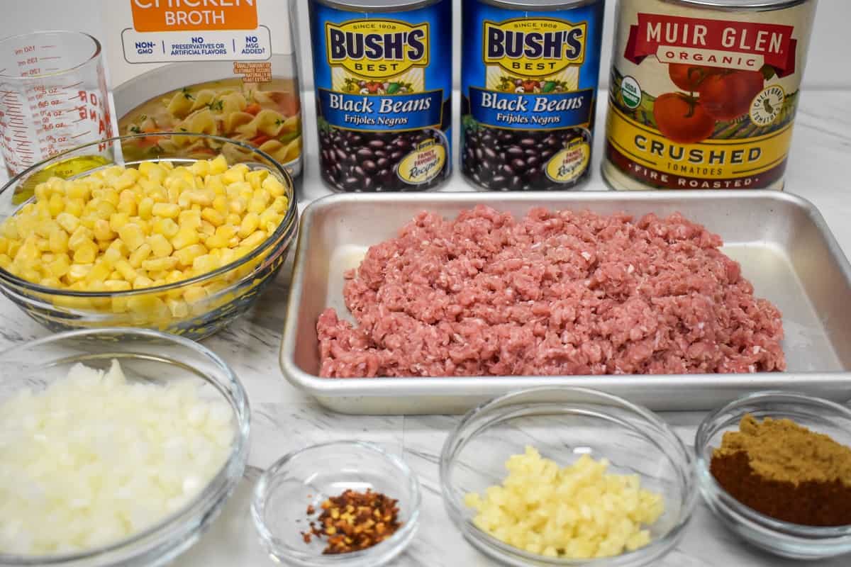 The ingredients for the turkey taco soup arranged on a white table.