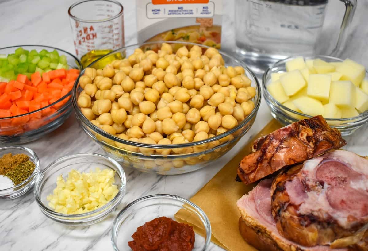 The ingredients for chickpea soup displayed on a white table.