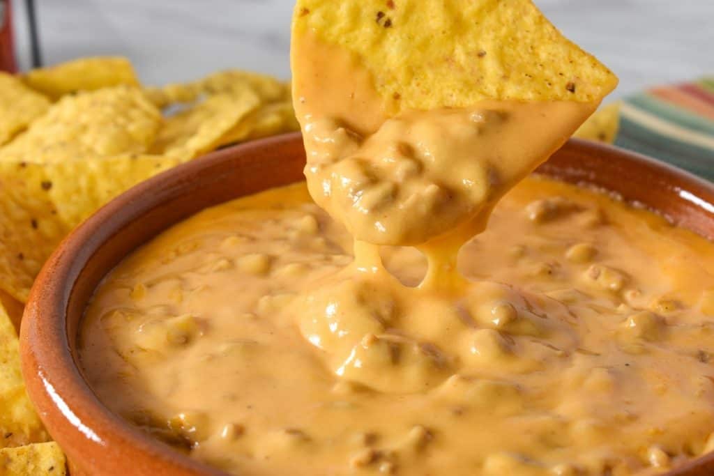 A tortilla chip dipped in the chorizo cheese dip.