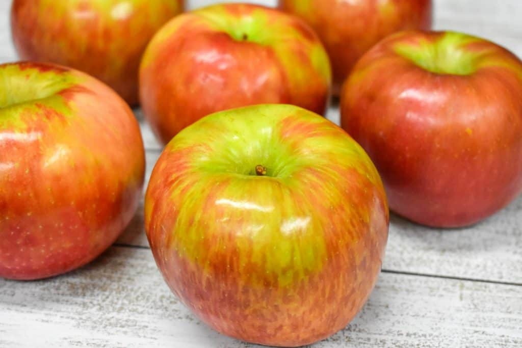 An image of Honeycrisp apples displayed on a white wood table