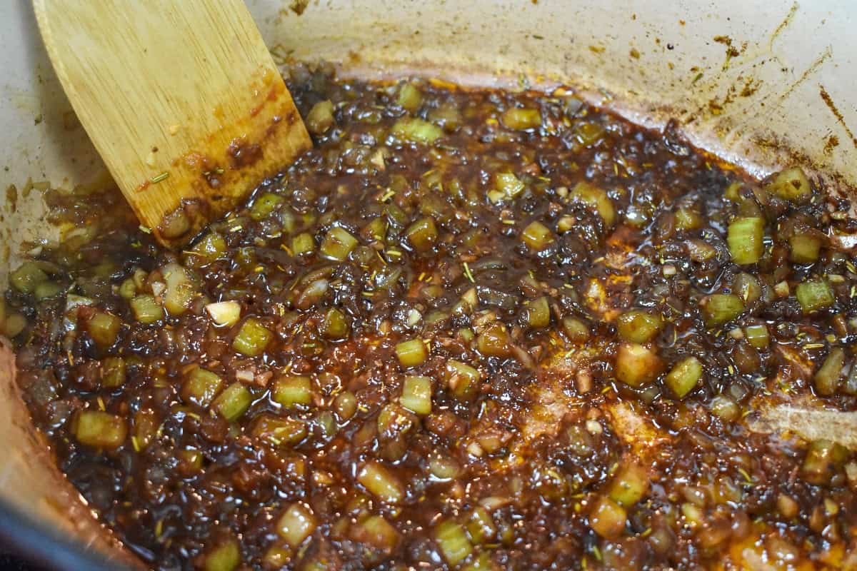 Red wine added to the onions, celery, garlic flavor base in a large pot.