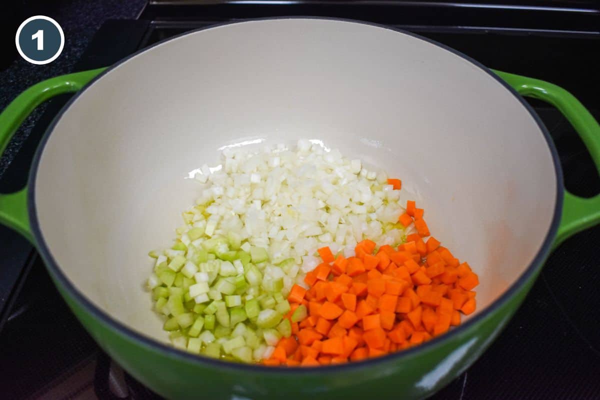 Diced onions, carrots, and celery cooking in olive oil in a large pot.