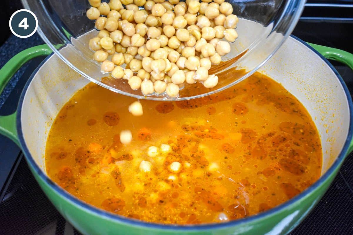 Drained canned chickpeas being added to the soup pot.