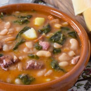 Cuban white bean soup (caldo gallego) served in a terracotta bowl.