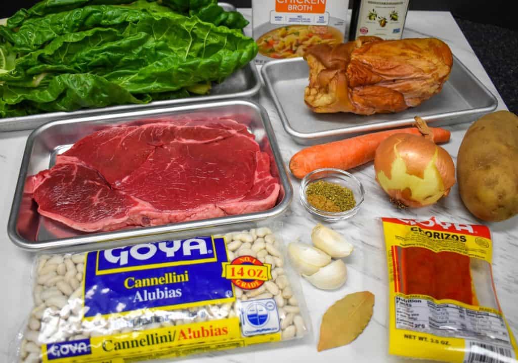 The ingredients for the Cuban white bean soup displayed on a white table.