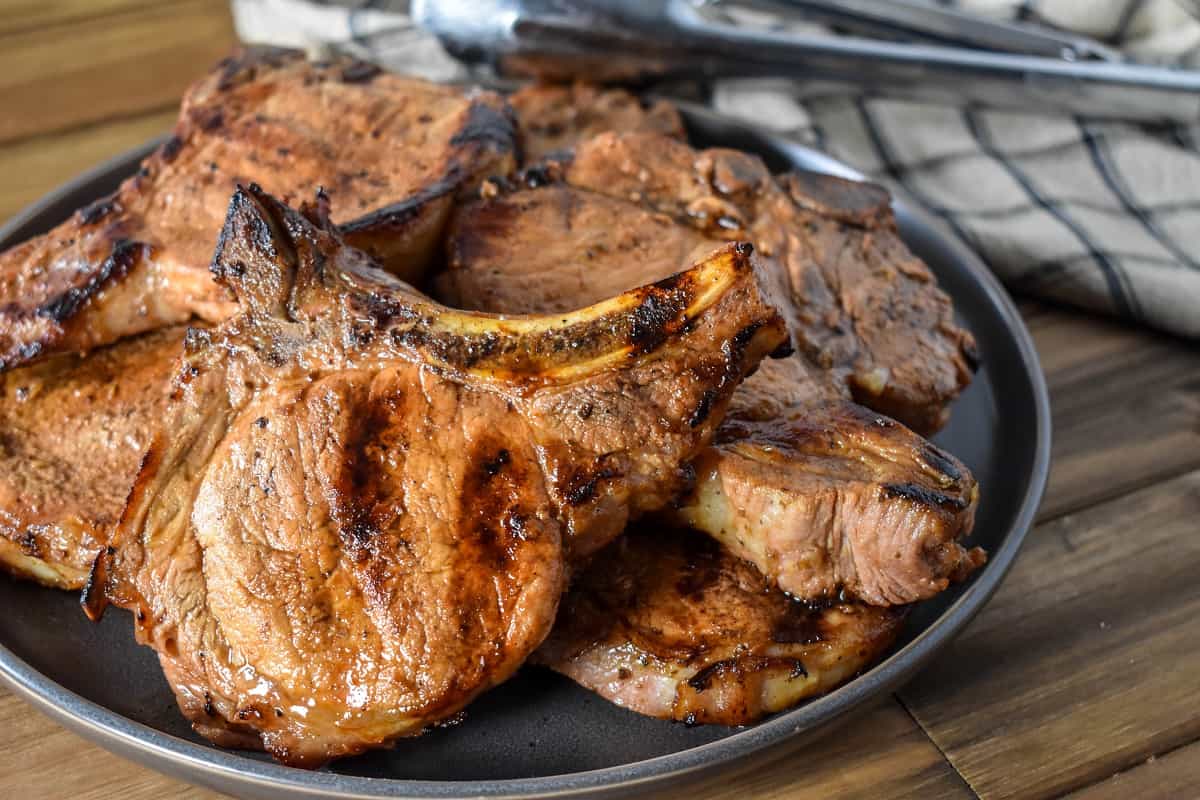 Grilled pork chops served on a large gray plate.