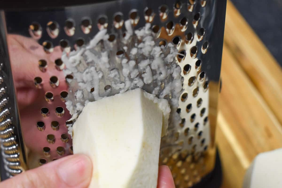 Malanga being grated on a box grater.