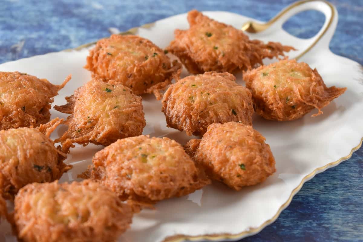 Malanga fritters displayed on a white platter.