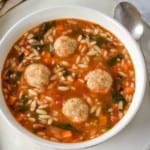 Chicken meatball soup in a red dutch oven.