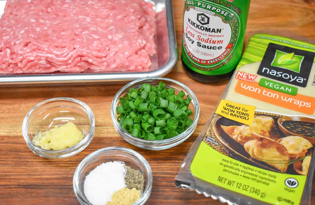 The ingredients for the potstickers arranged on a wood cutting board.