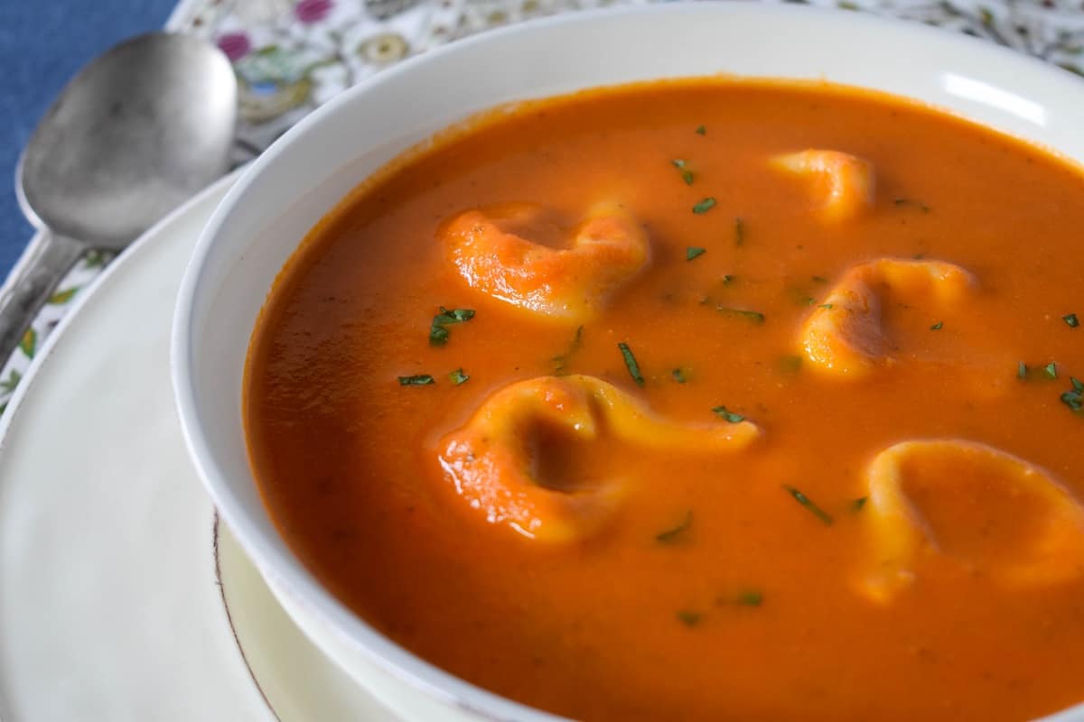Tortellini tomato soup served in a large white bowl.