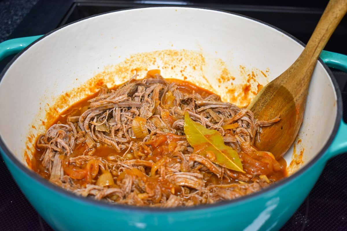 The shredded beef and sauce combined in the pot.