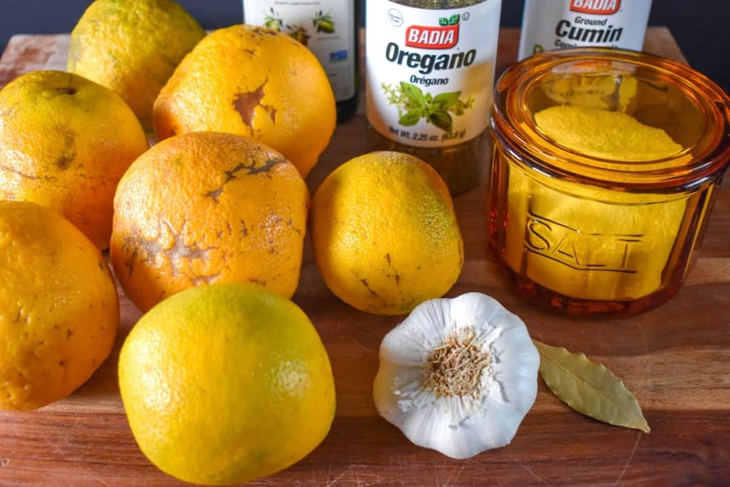 The ingredients for the mojo marinade before prepping, arranged on wood cutting board.