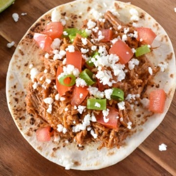 Shredded pork served on a soft tortilla shell and topped with diced tomatoes, green onions and queso fresco.