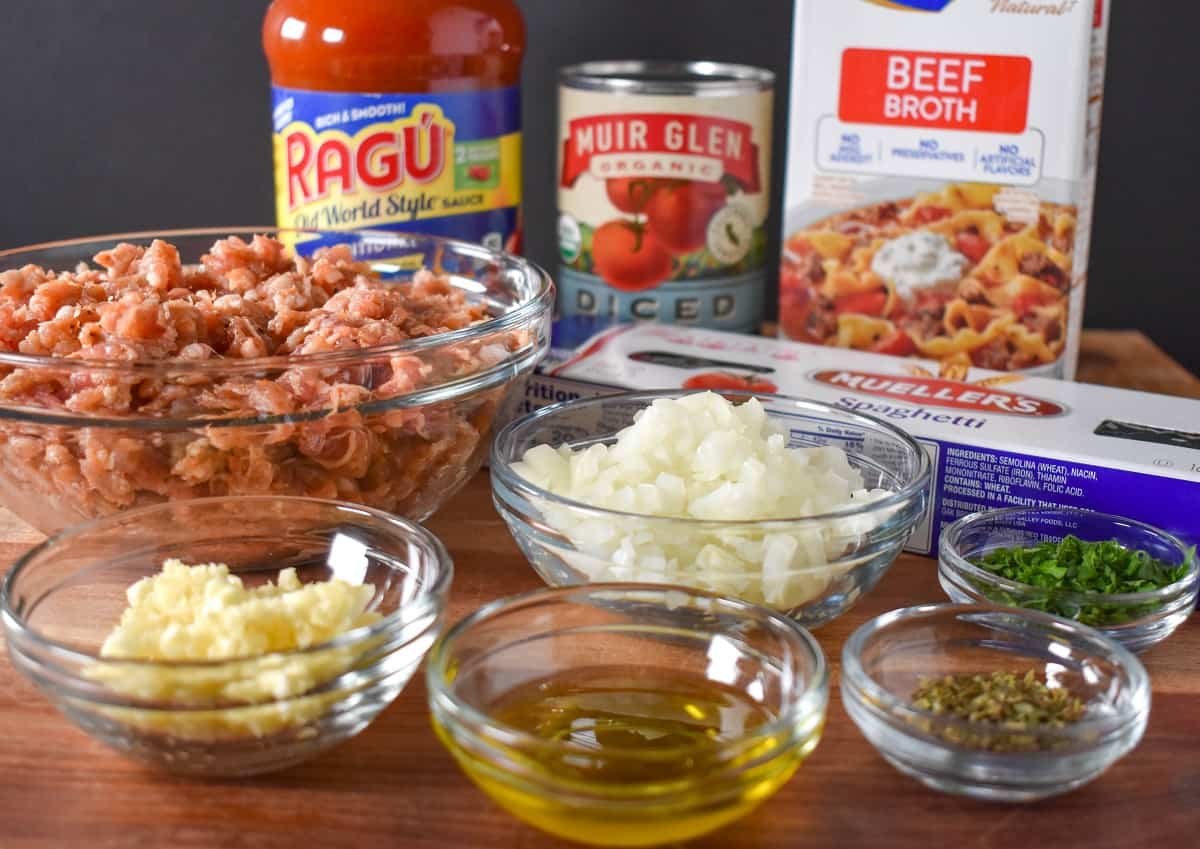 The prepped ingredients for the pasta dish arranged on a wood cutting board.