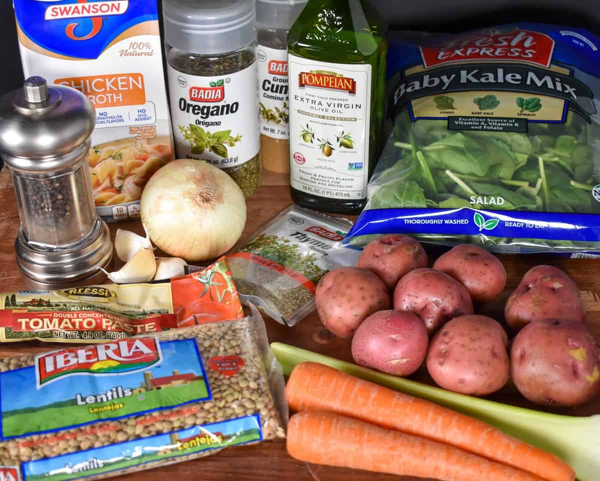 The ingredients for the soup displayed on a large, wood cutting board.