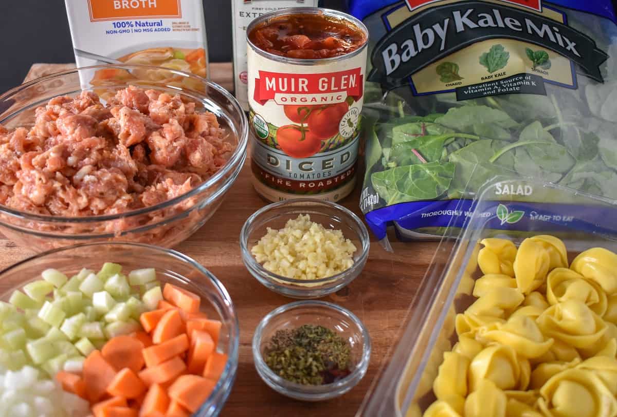 The prepped ingredients for the soup arranged on a wood cutting board.