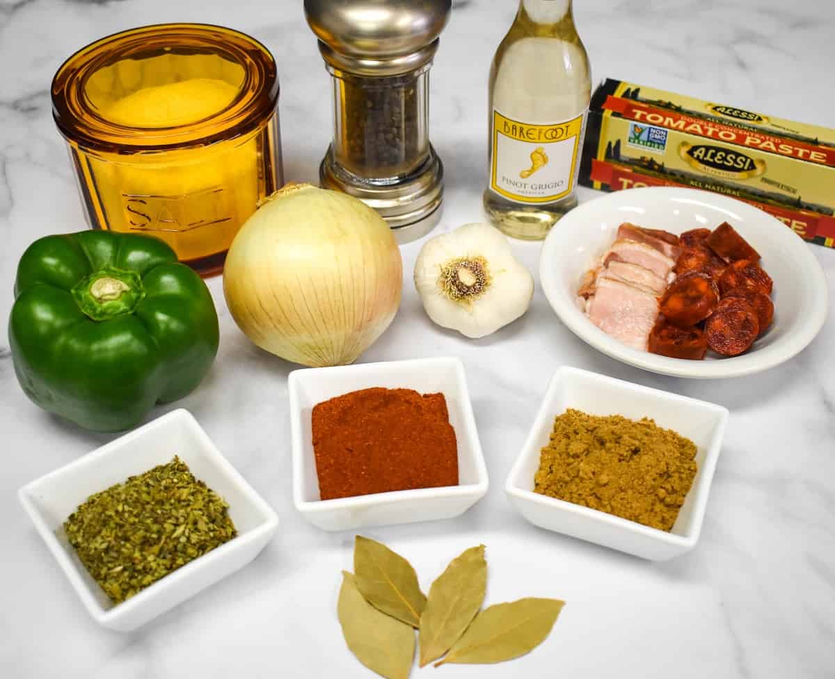 Ingredients commonly used in sofrito arranged on a white table.