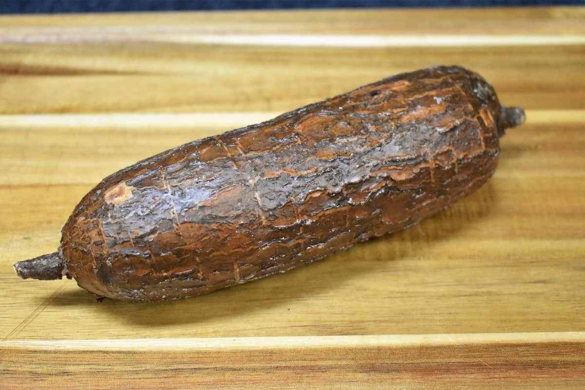 A yuca displayed on a wood cutting board.