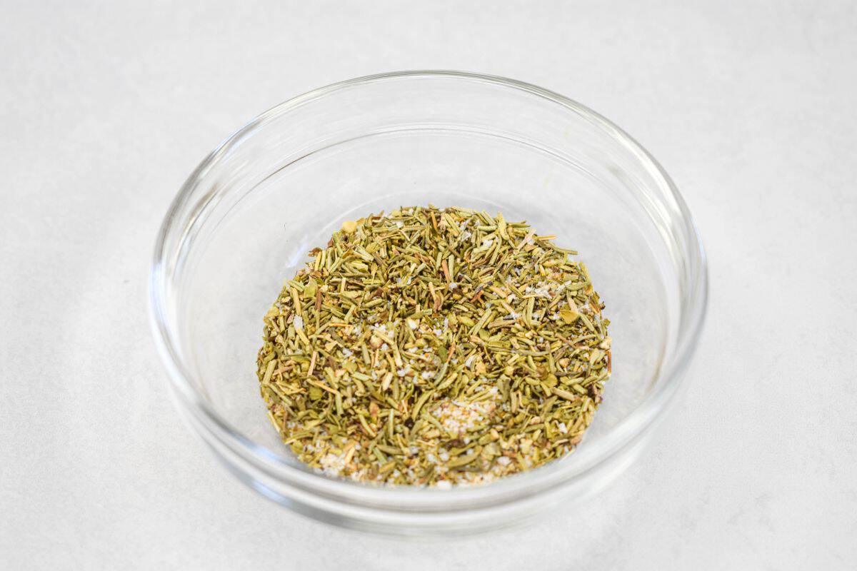 Seasoning in a small glass bowl set on a white table.