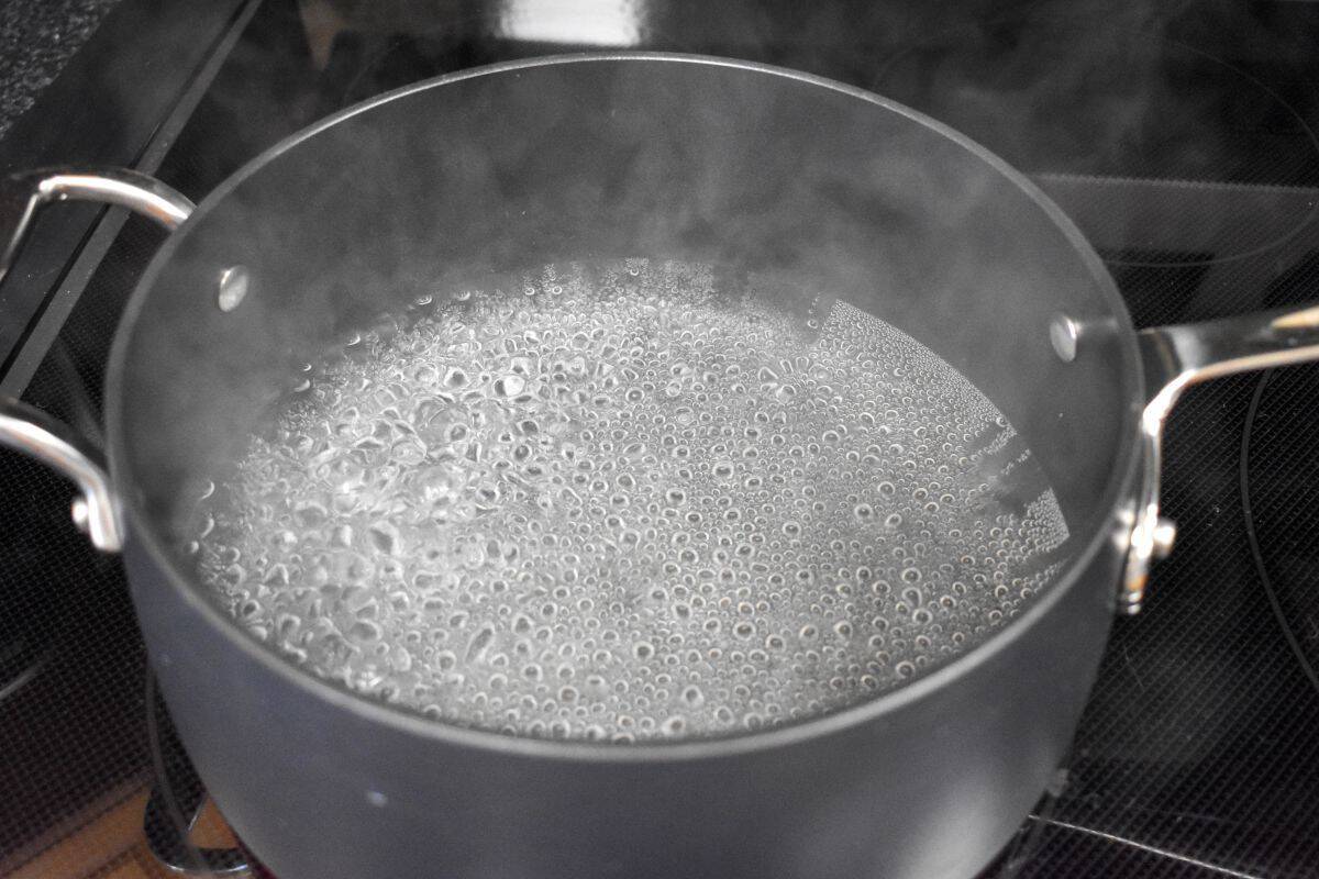 Water boiling in a black saucepan.