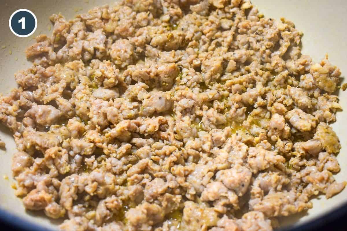 Italian sausage browned and crumbled in a large pot.