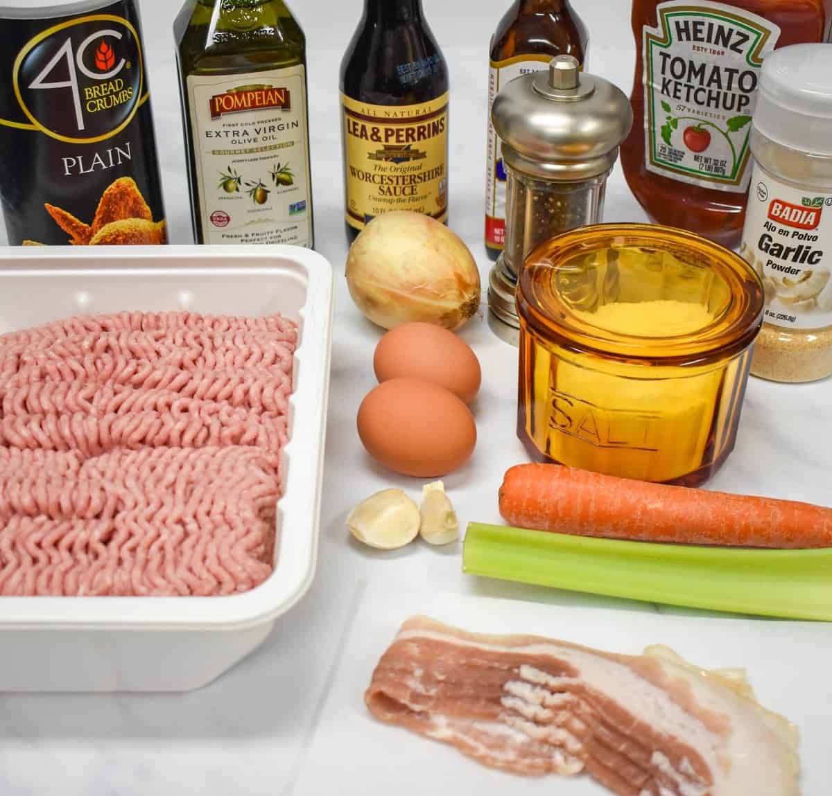 The ingredients for the meatloaf arranged on a white table.