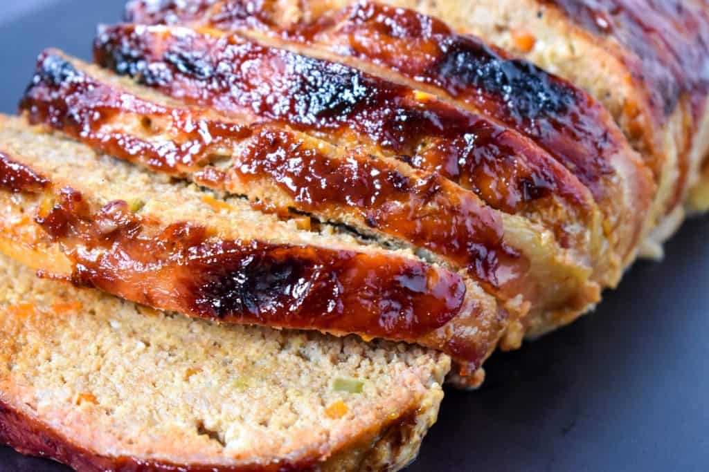 The turkey meatloaf sliced on black cutting board.