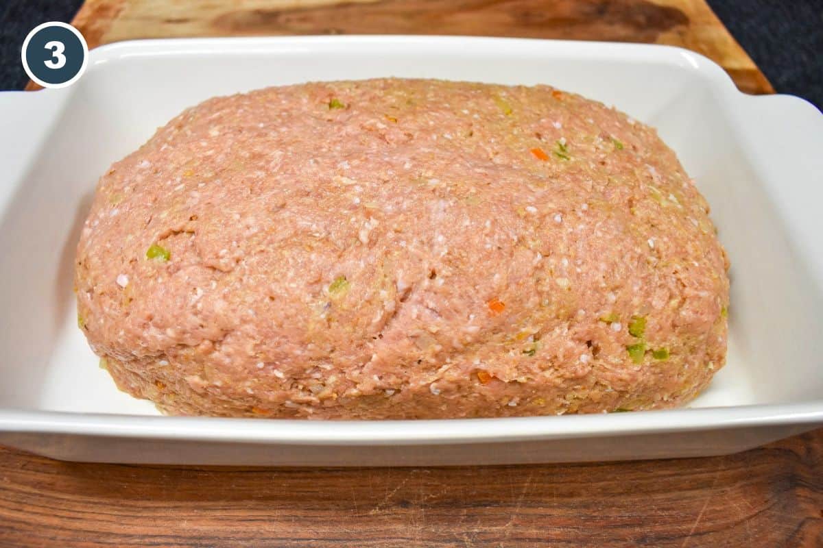Ground turkey meatloaf mixture shaped into an oval loaf in a baking dish.