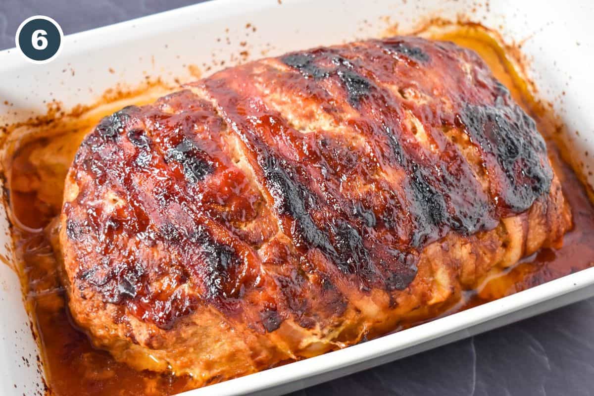 Baked turkey meatloaf with bacon and glaze in a white baking dish.