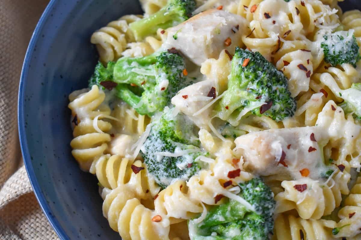 A close up of the chicken and broccoli pasta served in a blue plate.