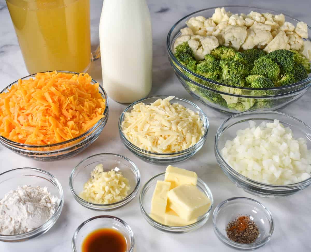 The prepped ingredients for the soup separated in clear bowls and arranged on a white table.