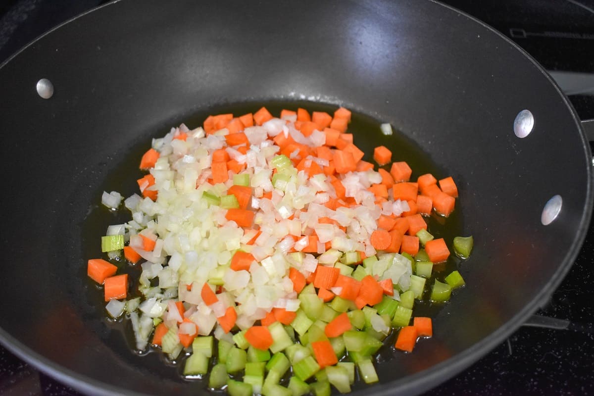 Diced onions, carrots and celery in a large, black skillet.