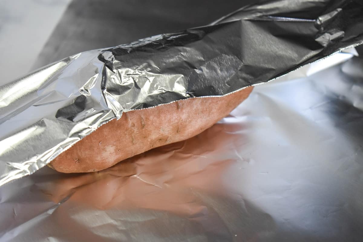 An image of wrapping a sweet potato in foil.