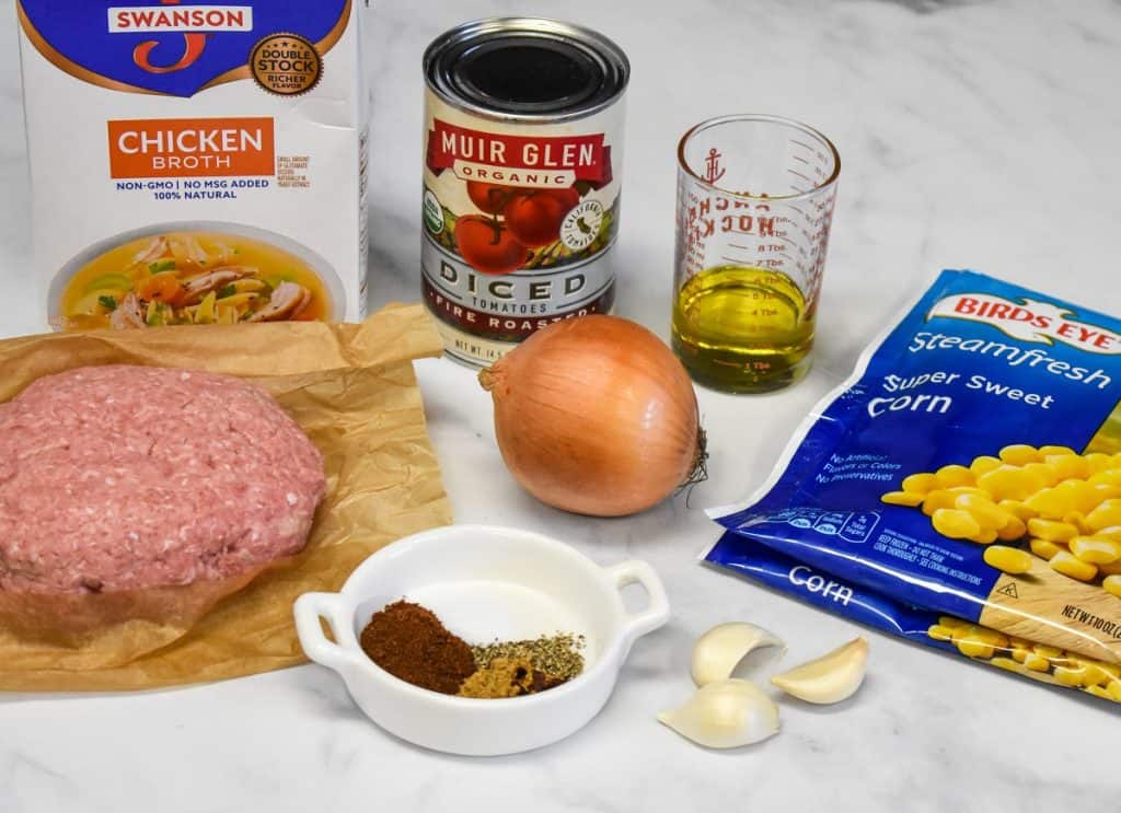 The ingredients for the turkey tortilla soup, except for the garnishes, displayed on a white table.