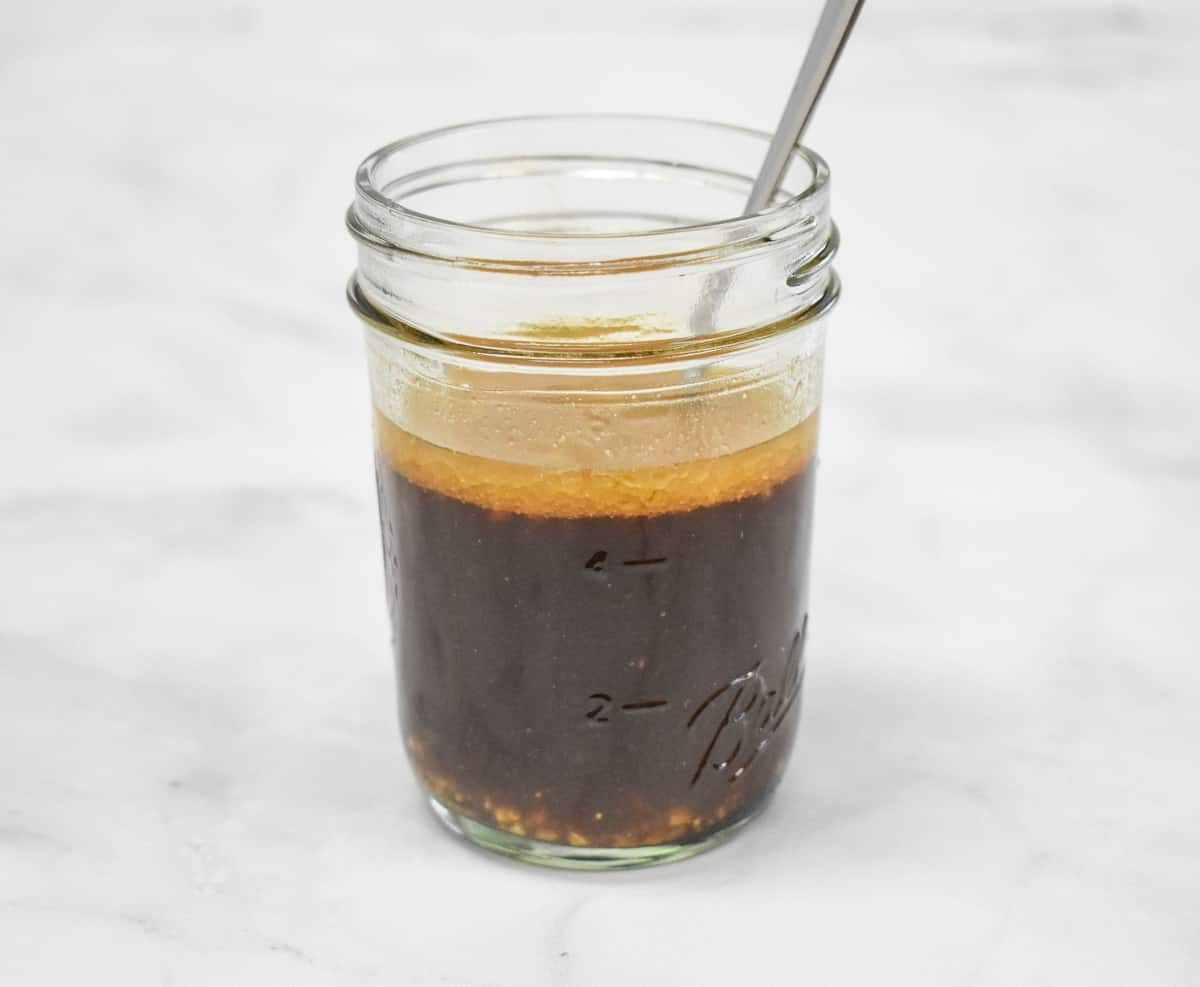 The Asian style sauce combined in a small canning jar and displayed on a white table.