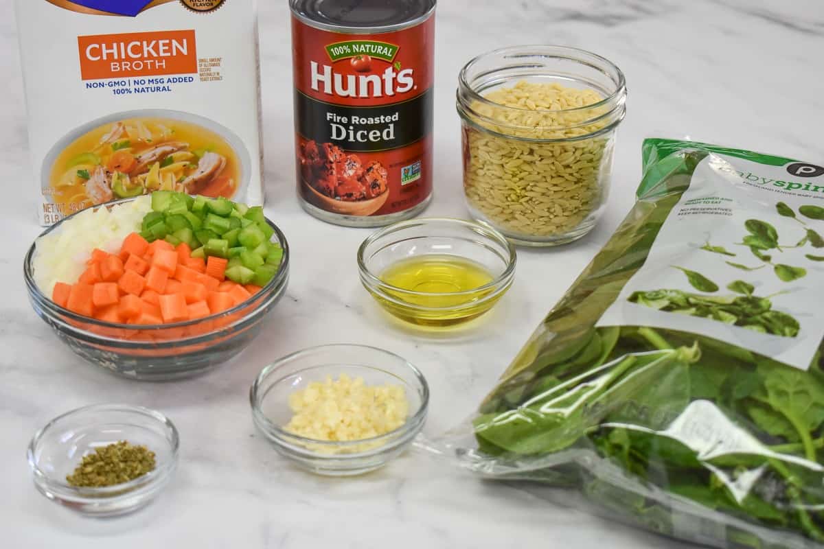 The prepped ingredients for the soup arranged on a white table.