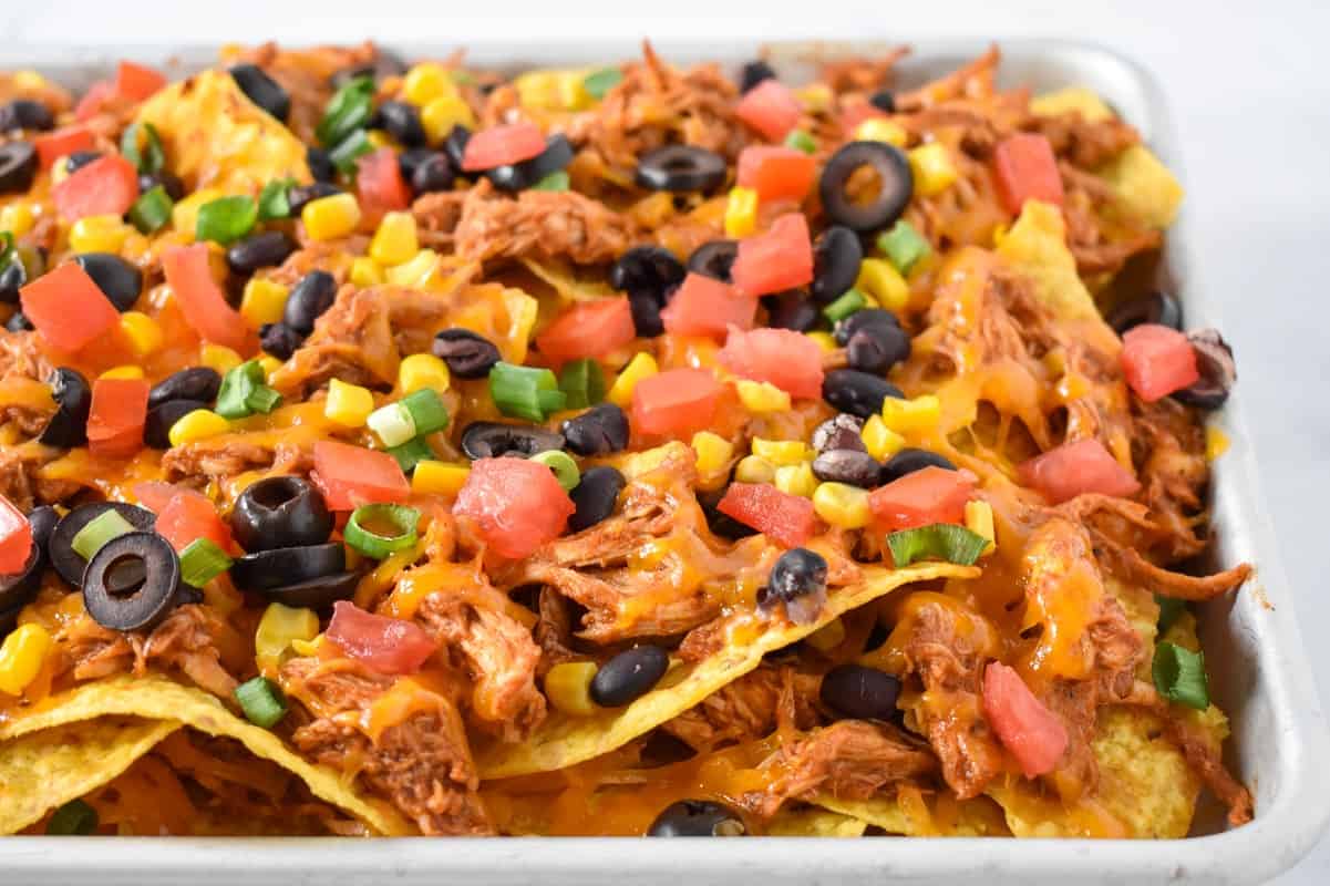 A close up of the nachos on a sheet pan.