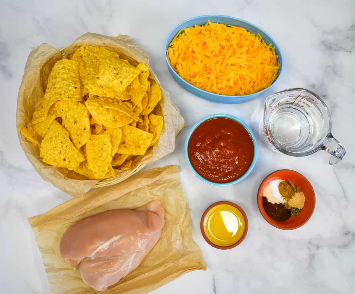 The ingredients for the shredded chicken nachos, except the topping, displayed on a white table.