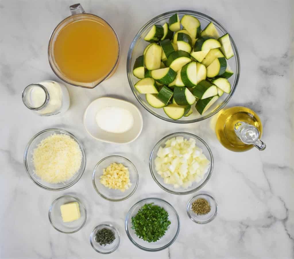 The ingredients for the soup prepped and separated into clear bowls, displayed on a white table.