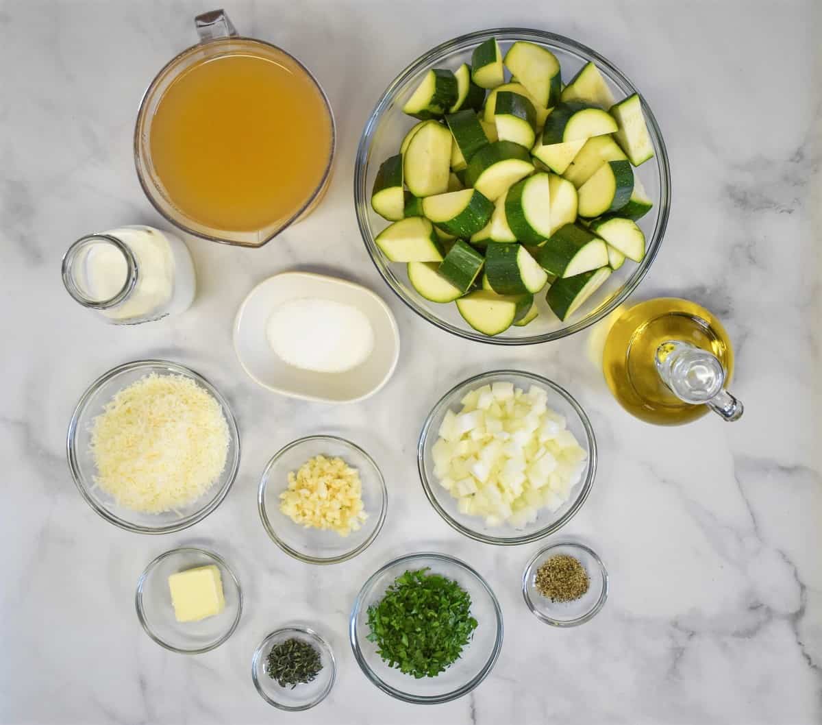The ingredients for the soup prepped and separated into clear bowls, displayed on a white table.