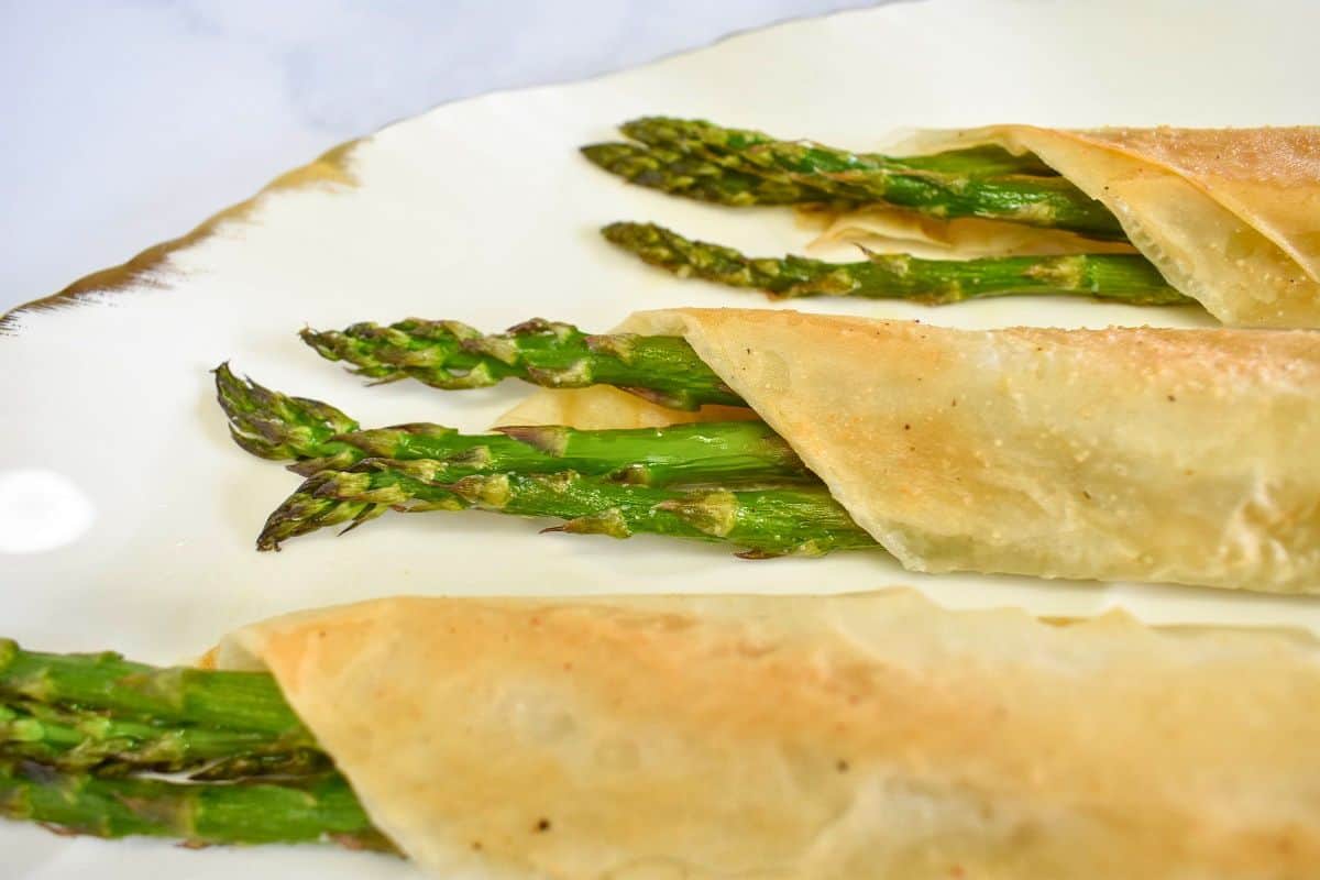Finished asparagus rolls served on a white platter.