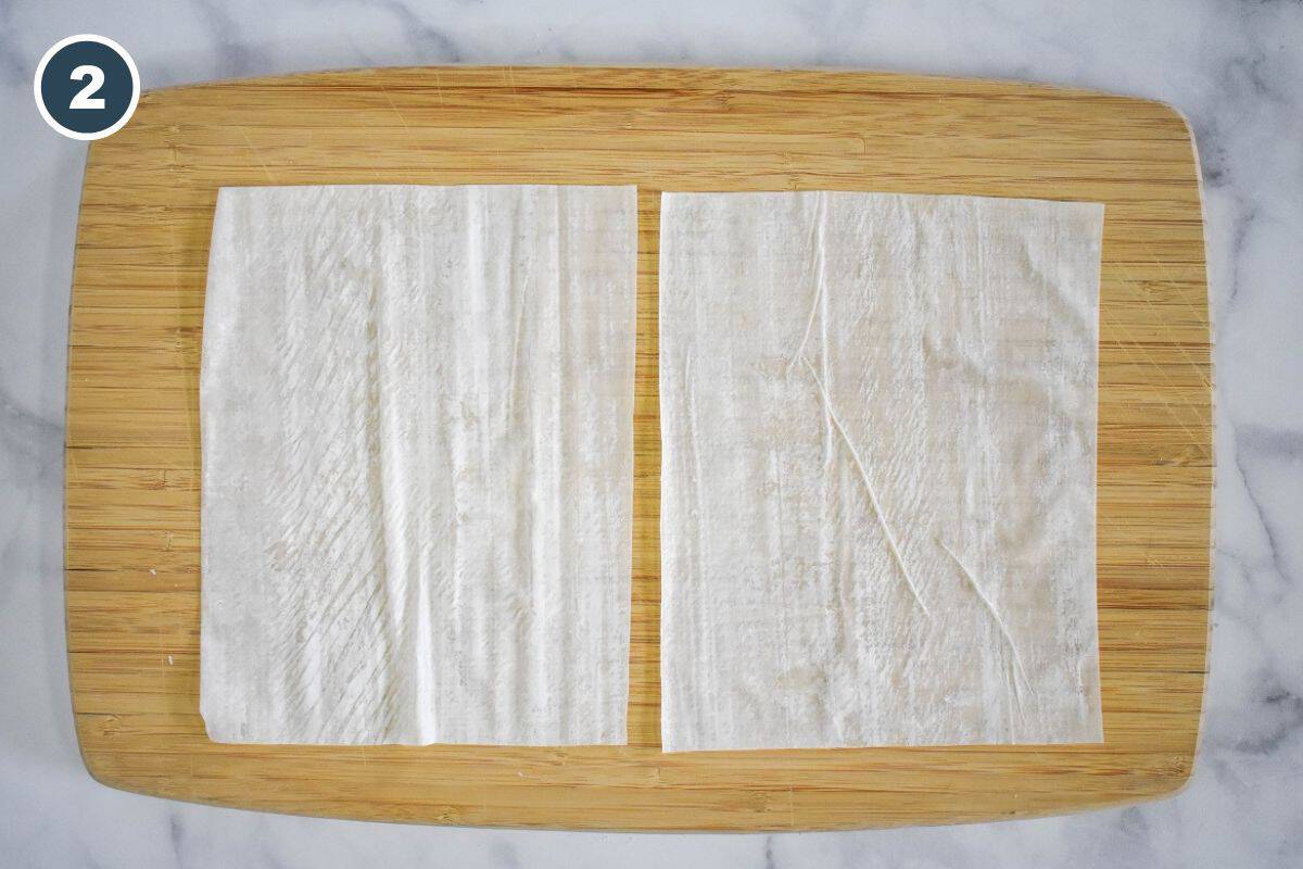Cutting the phyllo sheet in half lengthwise.